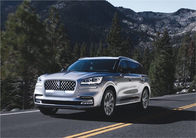 A 2023 Lincoln Aviator® Grand Touring SUV being driven on a winding road to demonstrate the capabilities of all-wheel drive | Lincoln of Wayne in Wayne NJ
