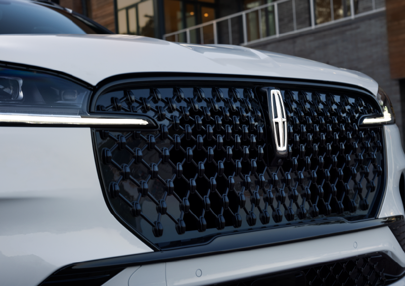 The black grille of a white 2025 Lincoln Aviator® SUV is shown with its fog lights on. | Lincoln of Wayne in Wayne NJ