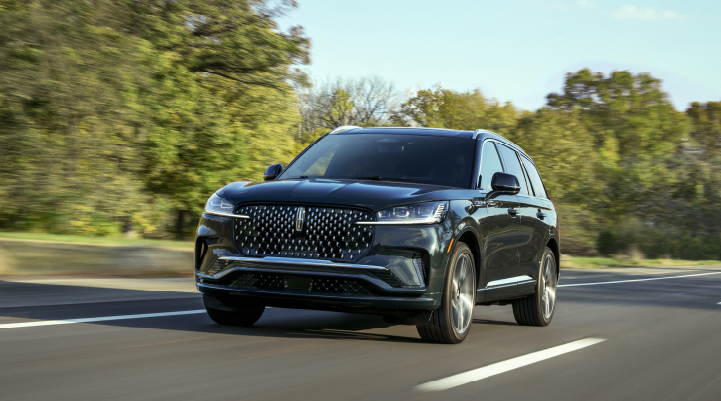 A 2025 Lincoln Black Label Aviator® SUV is being driven down a road lined with trees. | Lincoln of Wayne in Wayne NJ