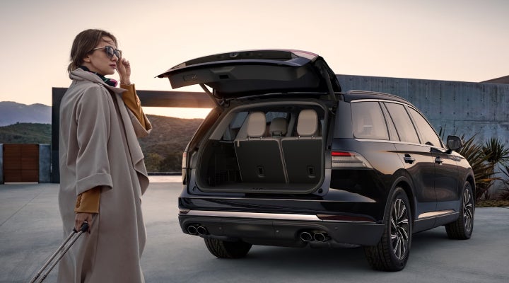 A woman approaches a 2026 Lincoln Aviator® SUV with its rear liftgate open. | Lincoln of Wayne in Wayne NJ