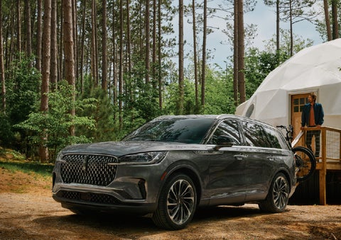 A 2027 Lincoln Aviator® is parked next to a high end glamping site. | Lincoln of Wayne in Wayne NJ