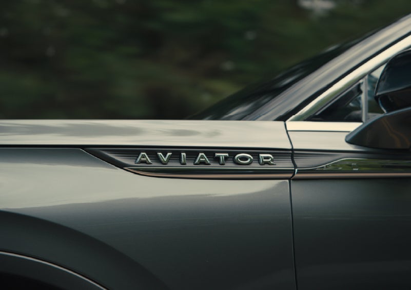 The driver’s side door and fender badging of a gray 2027 Lincoln Aviator® SUV are showcased. | Lincoln of Wayne in Wayne NJ