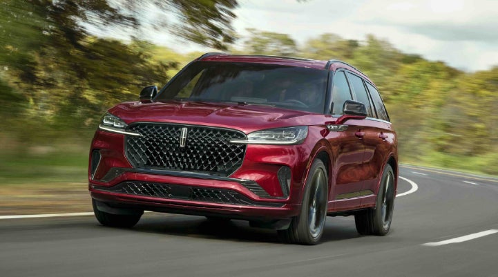 A 2027 Lincoln Aviator® SUV is being driven on a country road | Lincoln of Wayne in Wayne NJ