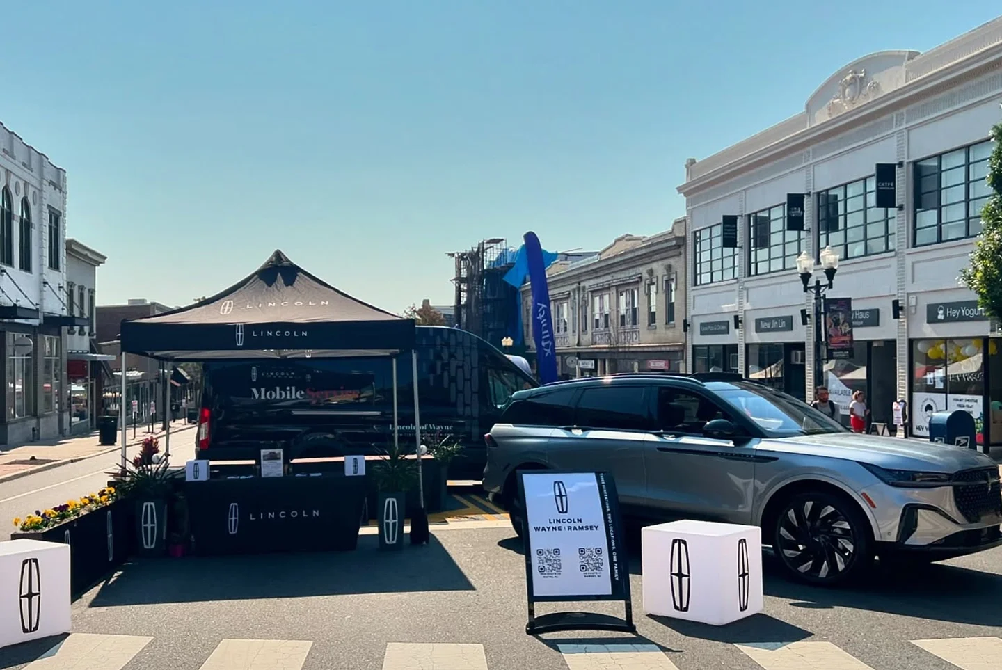 Lincoln Wayne display with SUV and branded tent at outdoor street event.